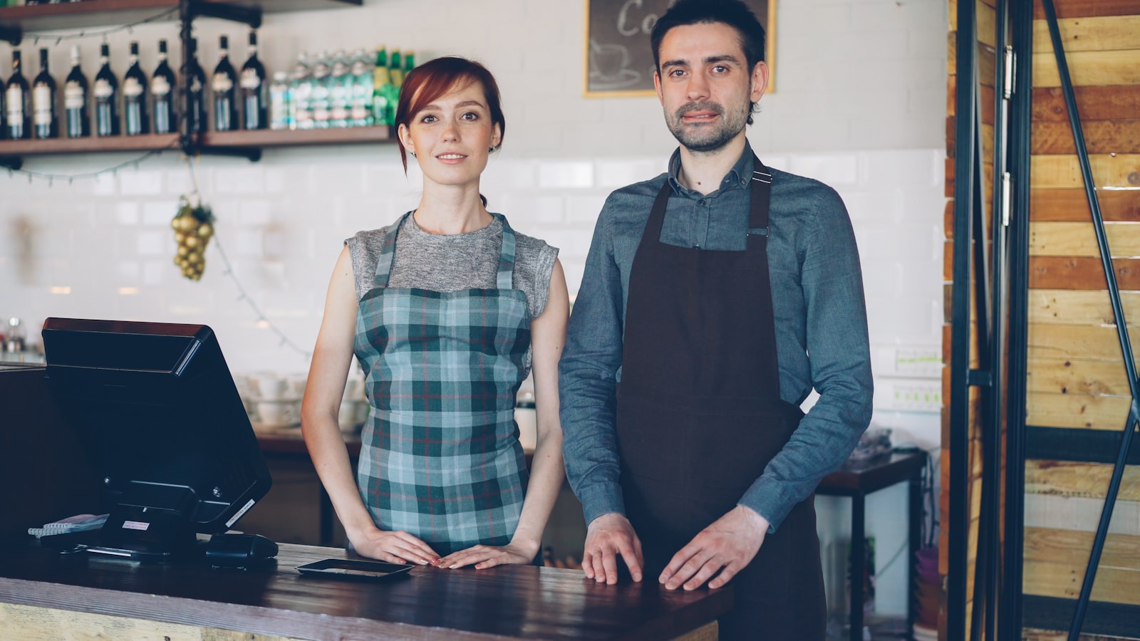 Two cafe workers standing behind the counter