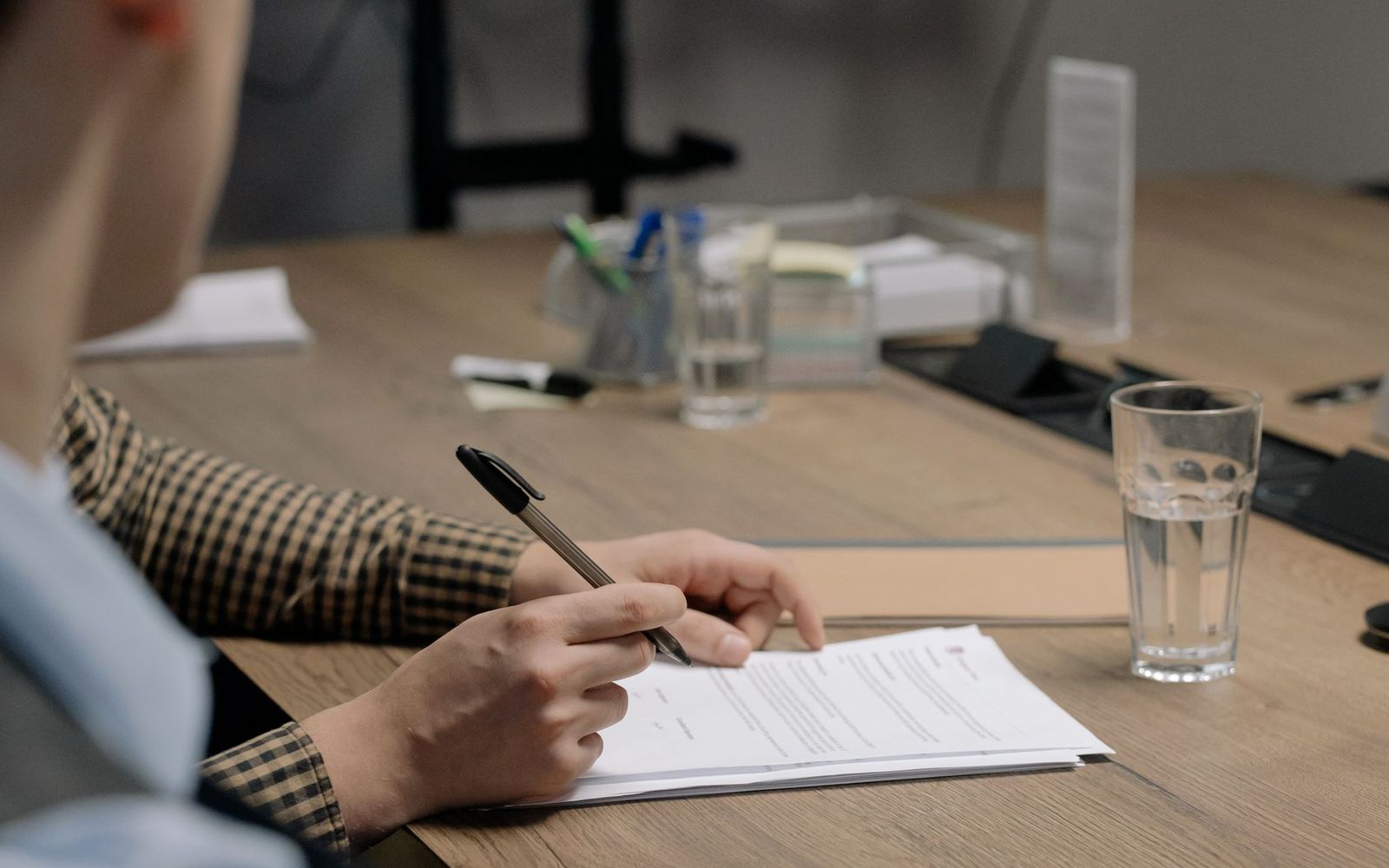A desk covered in papers and a laptop late at night