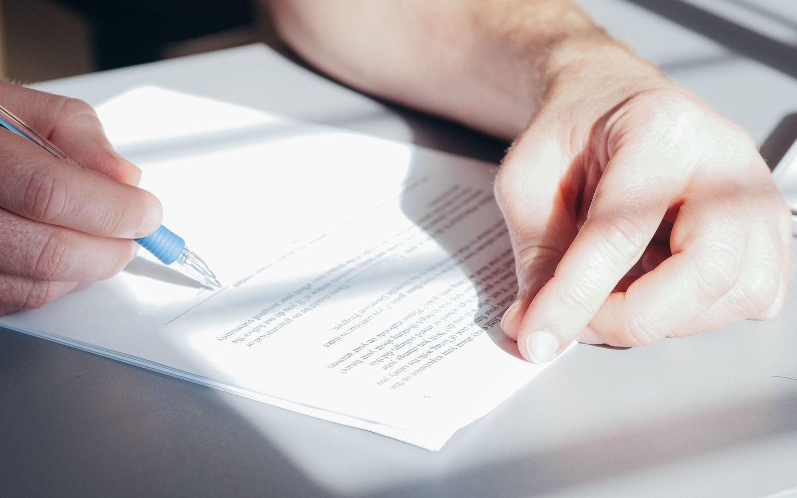 A close-up of someone holding printed paperwork