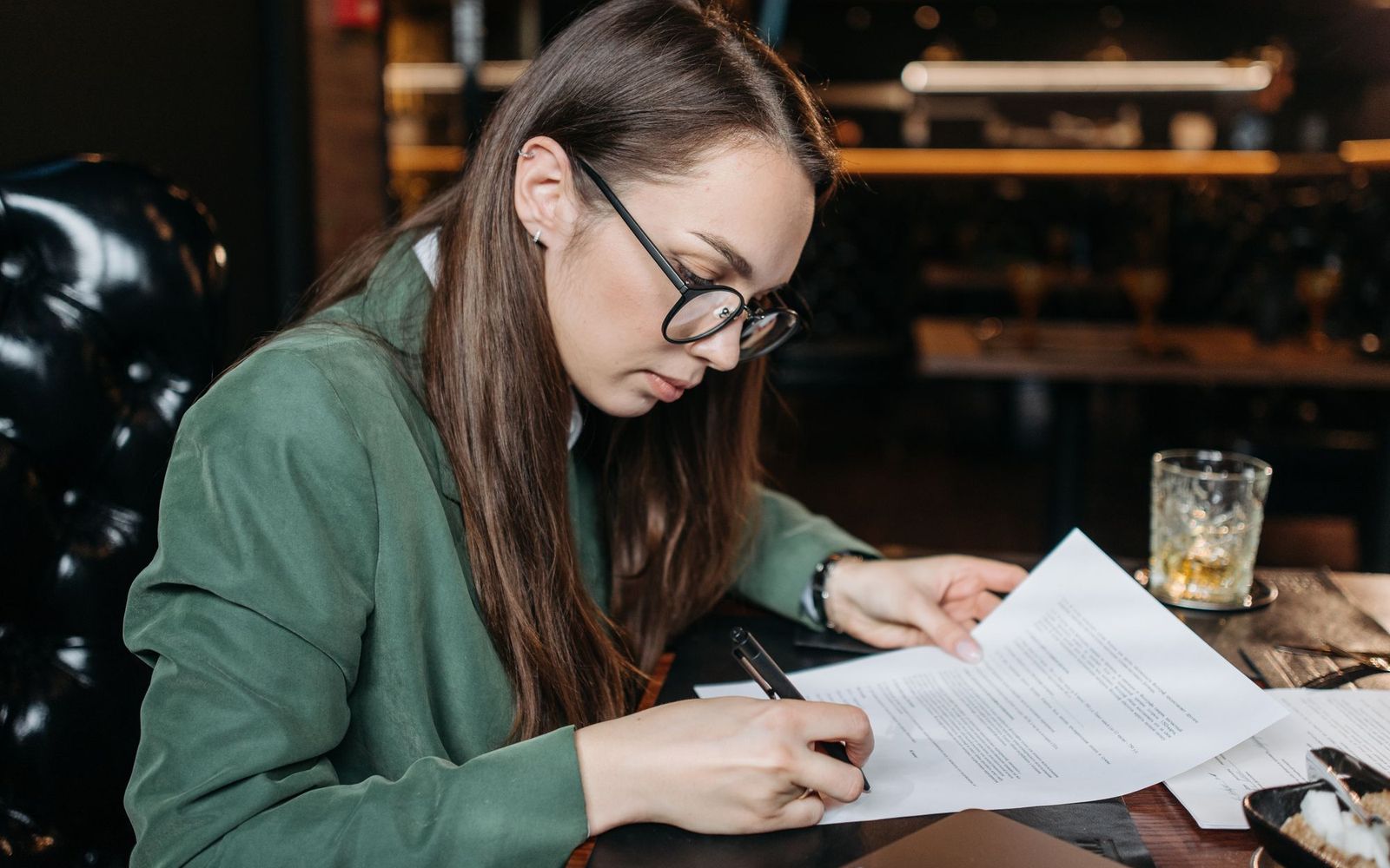 A desk with paperwork, a calculator and a laptop open on tax figures