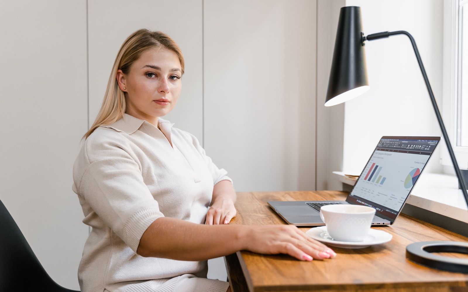 A laptop, coffee mug and phone set out on a desk