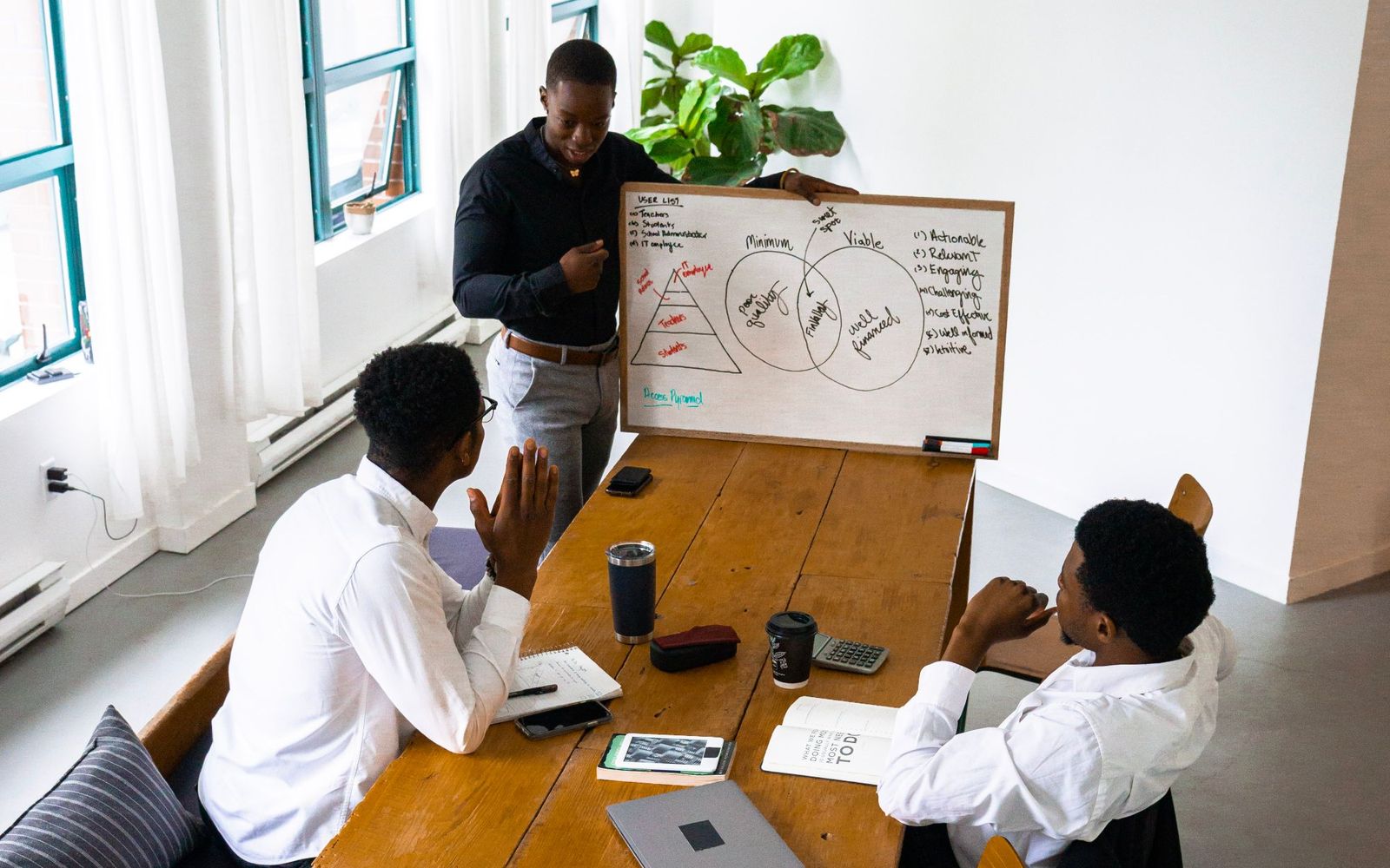 Colleagues taking notes around a table during a meeting