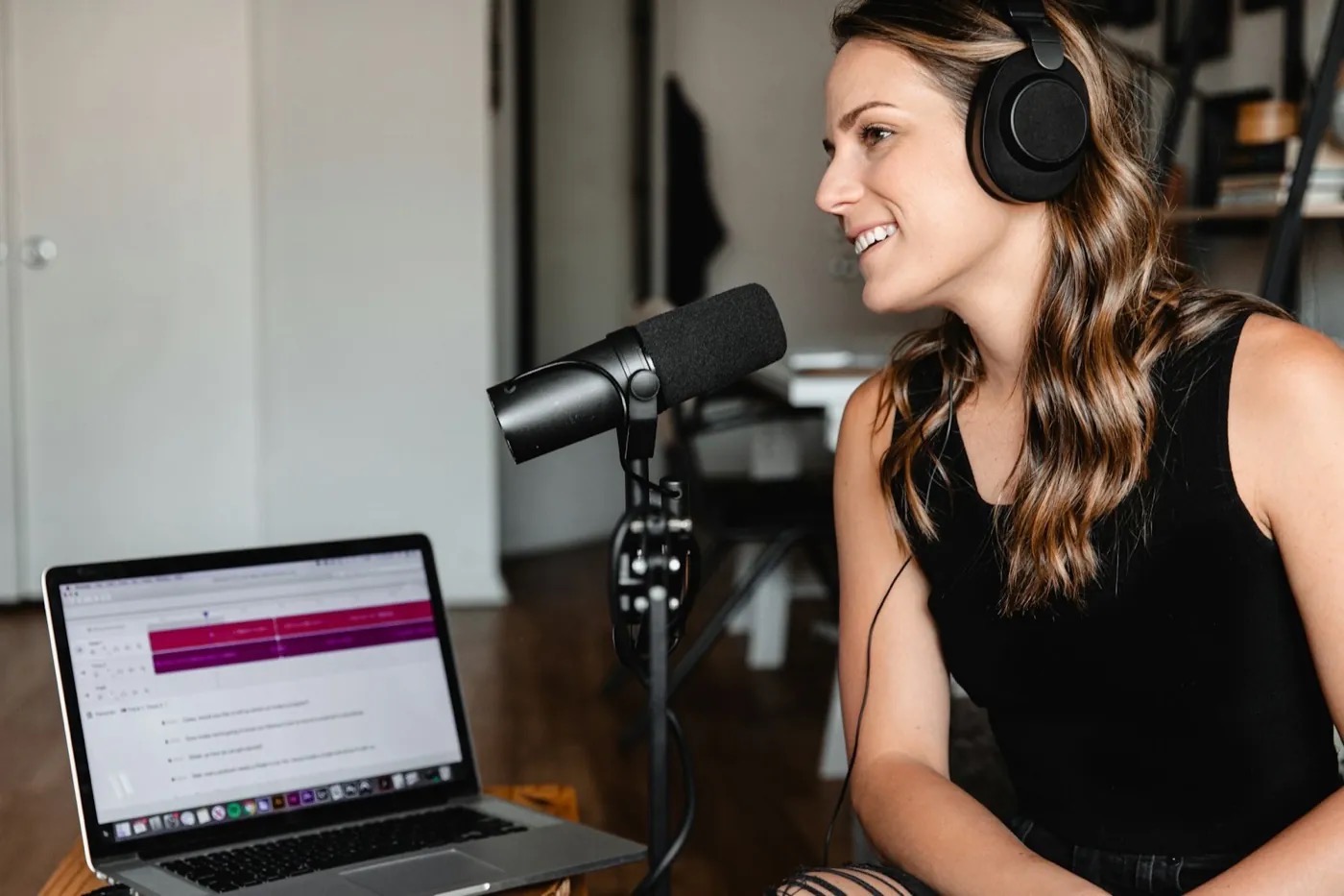 A creator recording a podcast with a microphone and laptop