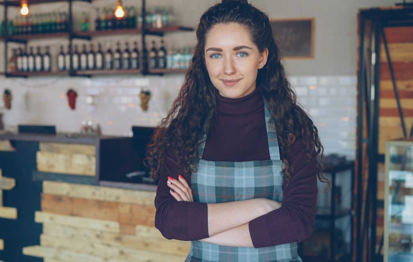 A cafe owner standing with arms crossed