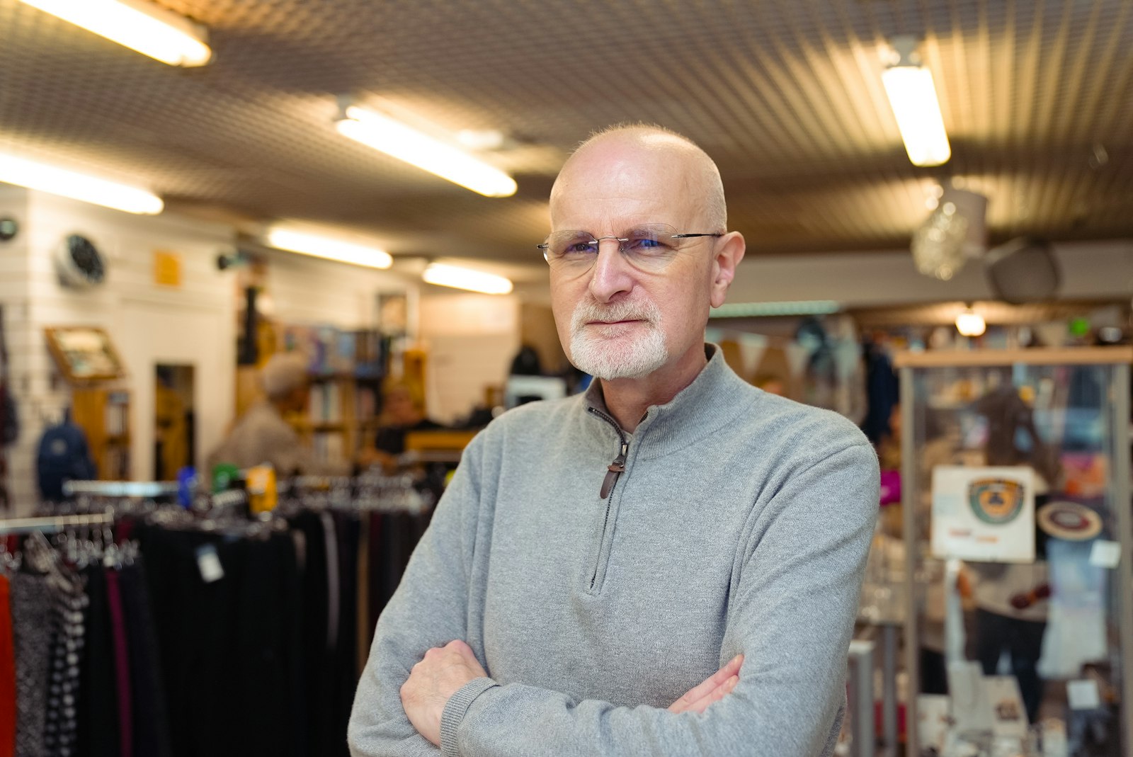 An independent shop owner standing behind the counter of his store